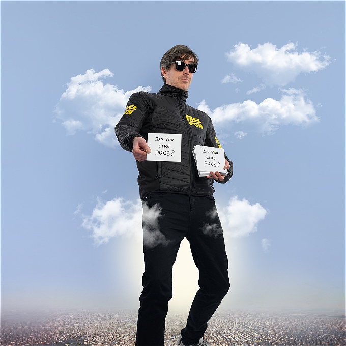 Wearing sunglasses Darren Walsh holds up small signs saying Do You Like Puns