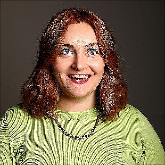 Kat Higgins wearing green top with a gray background