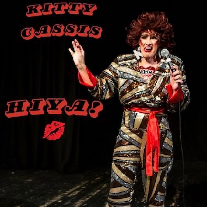 Kitty looks resplendent in gold, red and brown sequinned jumpsuit. Her signature red spiky hair stands on end, with a huge K dangly earring