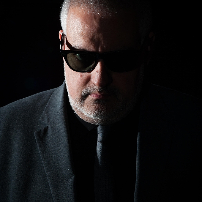 Male comedian scowling with suit and sunglasses
