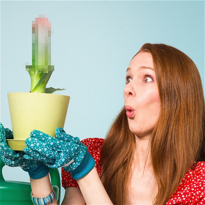Surprised female comedian holding a pot plant with a rude looking vegetable inside it