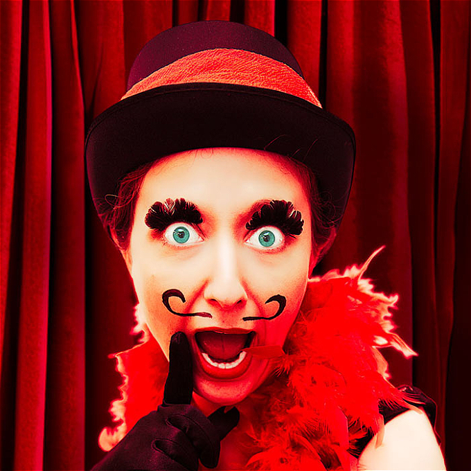 Female Cabaret Performer with moustache in a wow facial expression