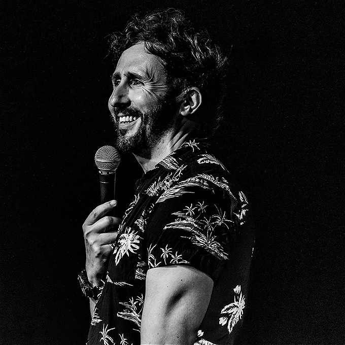 Nathan Cassidy holding a mic in black and white