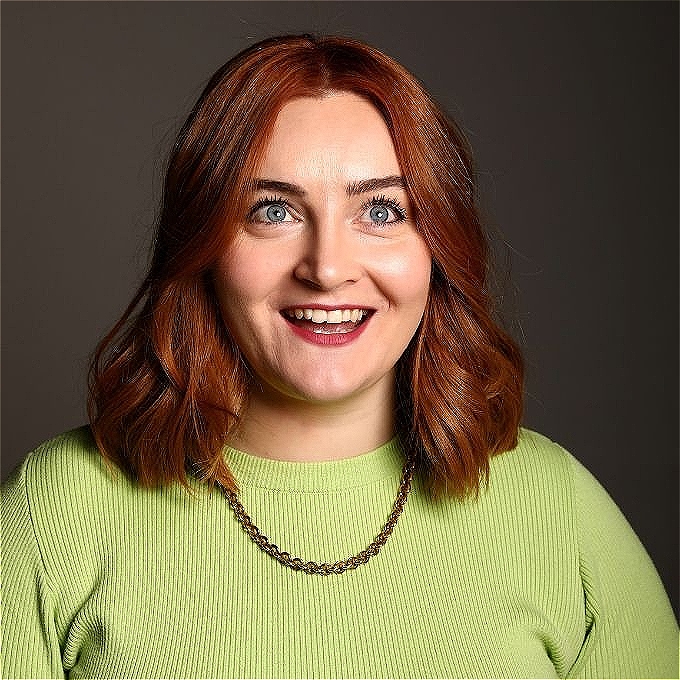 Kat Higgins wearing green top with a gray background