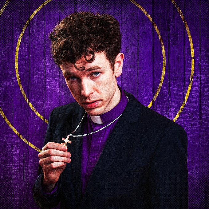 young vicar holding small crucifix on chain around his neck