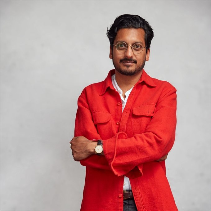 Ahir Shah with a neutral expression and folded arms