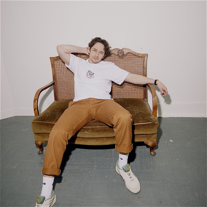 Milo sits on a chair looking relaxed