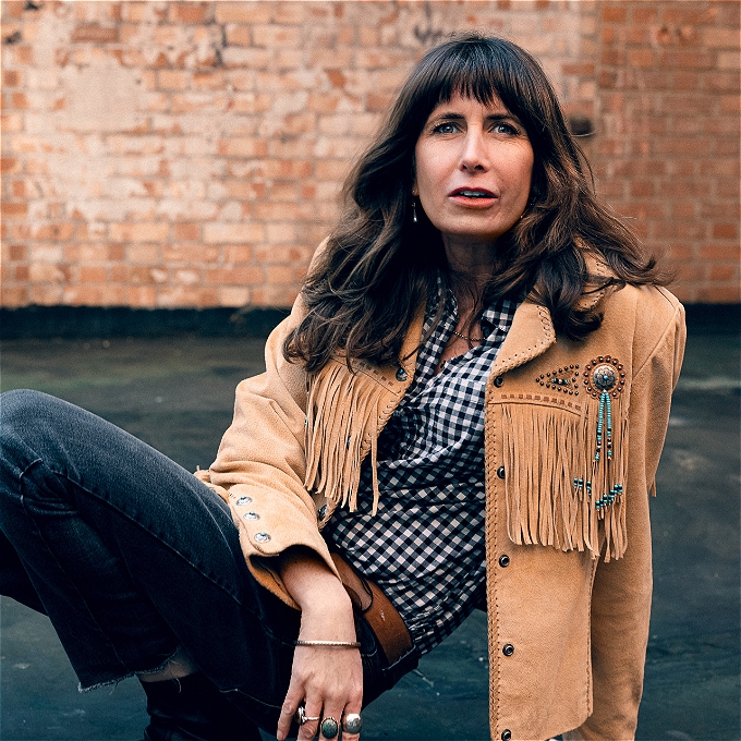 Female comedian in suede fringe jacket