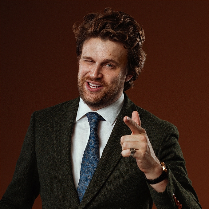 Male comedian pointing, making a commitment to all of you.