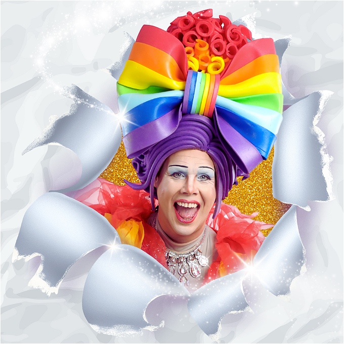 A pantomime dame is bursting through paper. She has a big rainbow wig on, blue eyeshadow, and bright red lips that frame a big smile. Her coat is rainbow coloured and she is wearing a silver necklace that sparkles in the light. White stars are swooshing around her.