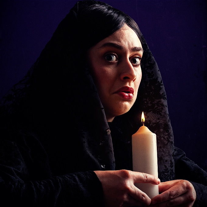 Zoe is wearing all black and holding a vigil candle