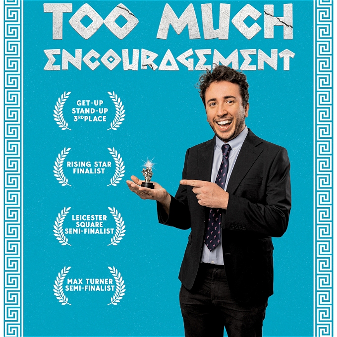 Man in suit stares at camera, smiling, while pointing proudly at a tiny trophy. Above him is the text 