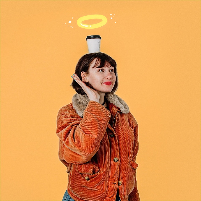 Female comedian looking into the distance with a coffee cup on her head and a halo hovering over.