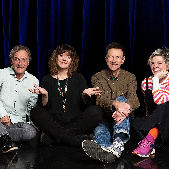 Coemdians Richard Vranch, Josie Lawrence, Lee Simpson and Ruth Bratt sit smiling on an empty stage