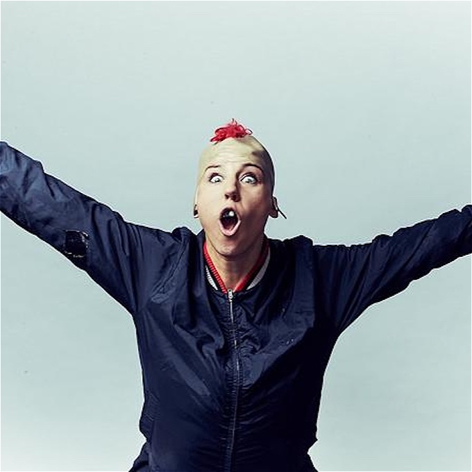 Punk with arms out female comedian black jacket