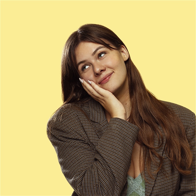 Female comedian smiling in front of yellow background