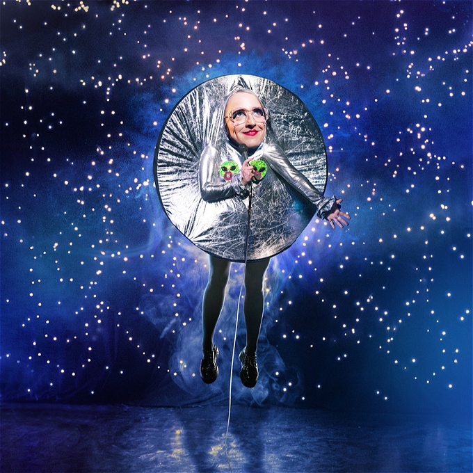 Dressed as the moon Lucy Pearman floats against a background of stars