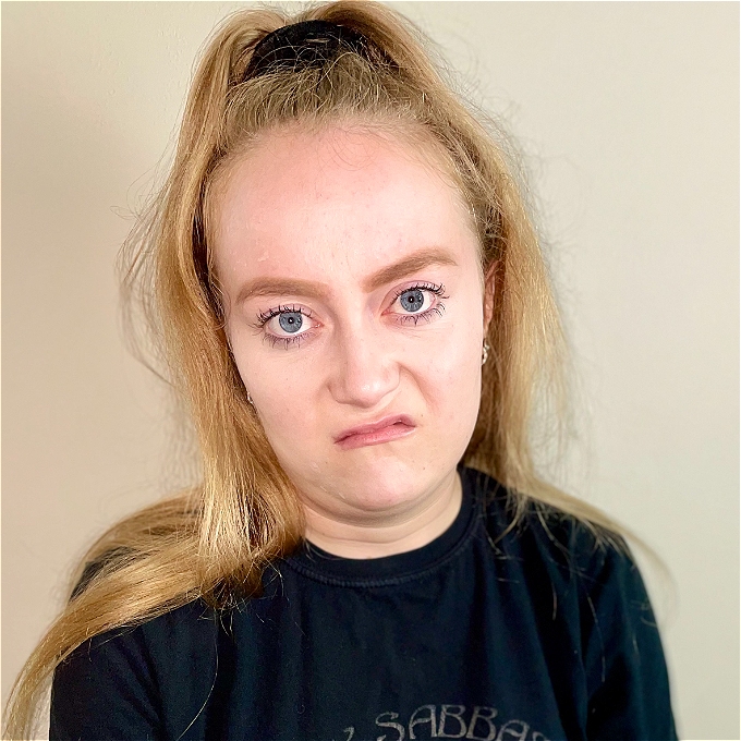 Miserable looking blonde female comedian, hair in a high pony - overly large forhead