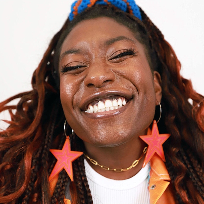 Sophie Duker smiles extremely broadly at the camera