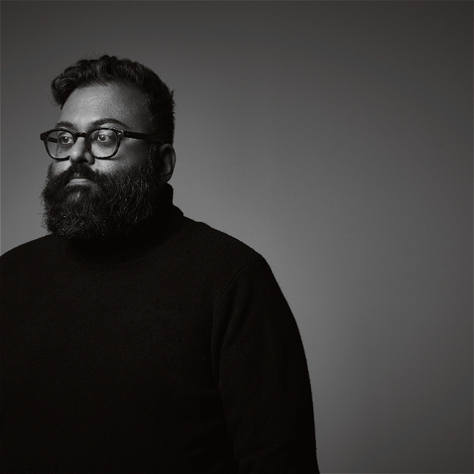 black and white picture of a stern faced Sunil Patel wearing a black sweater