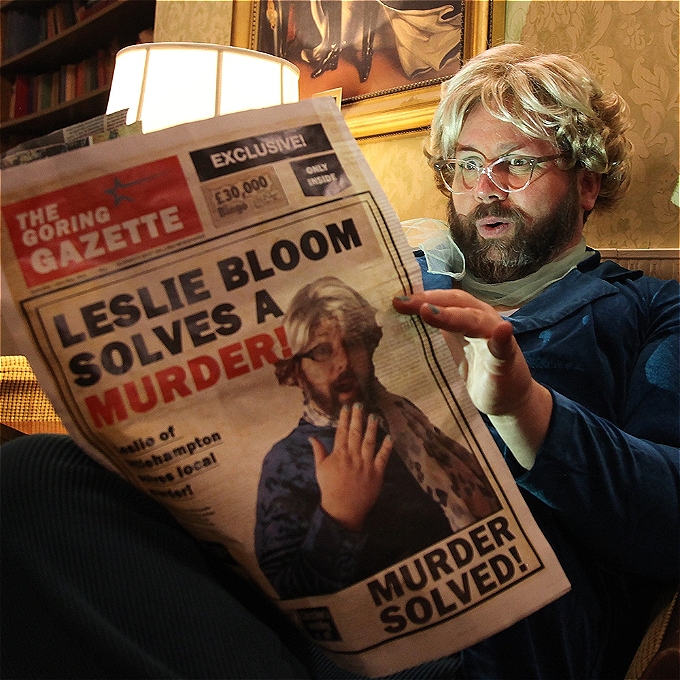 Comedian looks shocked as they read a newspaper with a head line about local murders