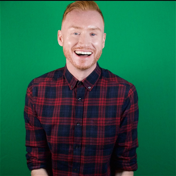 Gay man with ginger hair smiling.