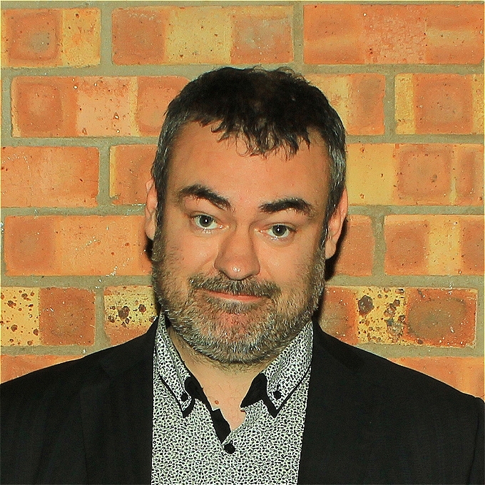 Matt Hollins In Front of A Brick Wall