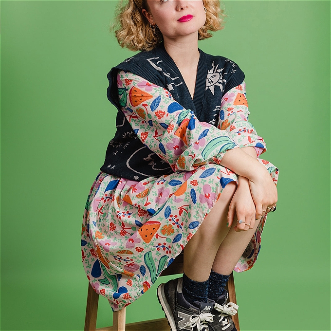 Female comedian sitting on a step looking up to the sky
