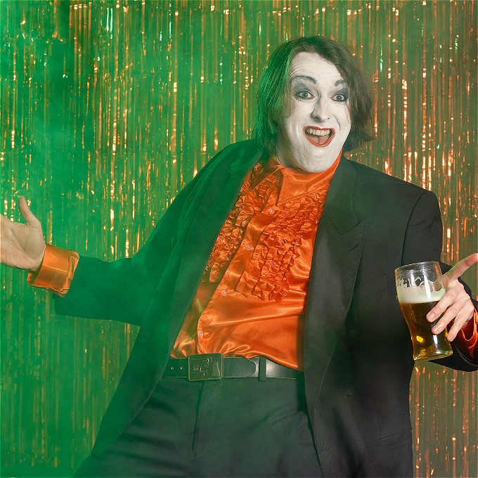 Joe Kent-Walters in a working mans club with white face make up as Frankie Monroe holding a pint arms outstretched