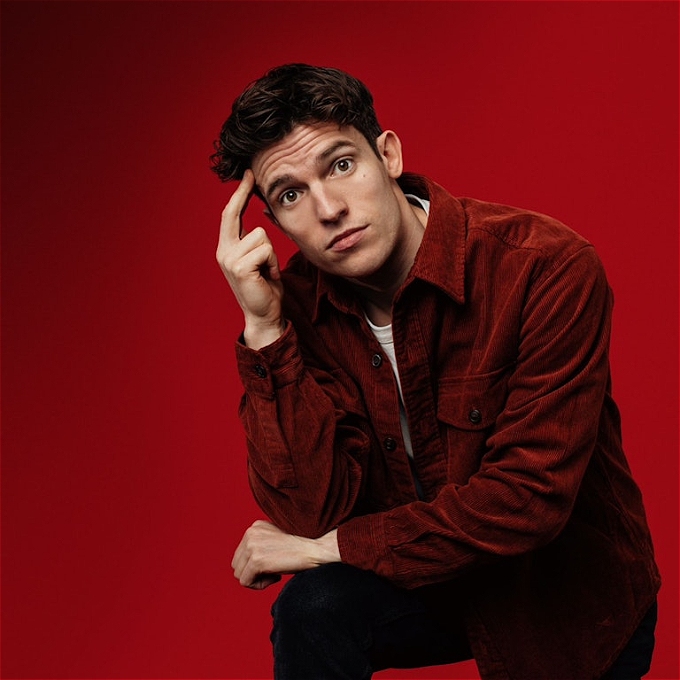 A slightly perplexed Patrick Spicer with two fingers on his temple