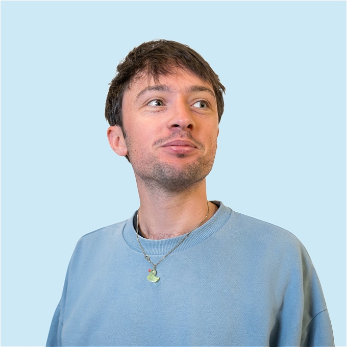 Comedian standing, posing for photo.