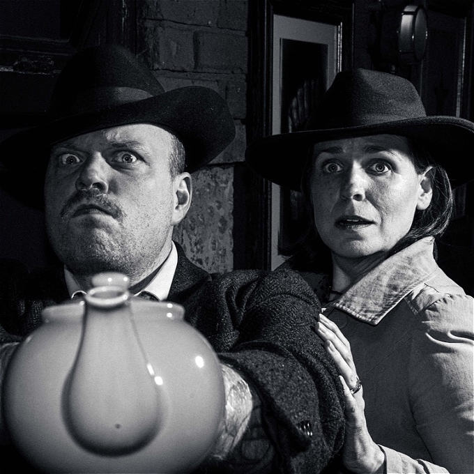 Detective and Femme Fatale are in a striking noir pose. The Detective is pointing a teapot instead of a gun.